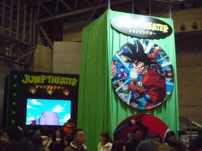 Estande Jump Theater na Jump Festa, com painel de Dragon Ball e visitantes