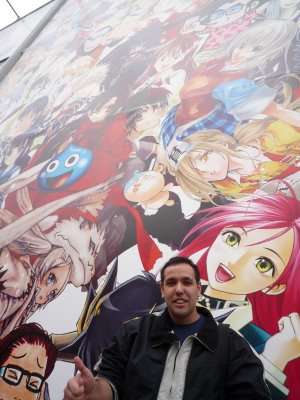 Visitante diante de um painel ilustrado com personagens na Jump Festa