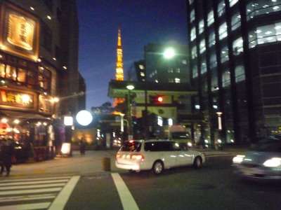 Tokyo Tower iluminada ao fundo de uma rua de Tóquio à noite