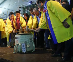 Autoridades nikkeis participando da quebra do taru, durante a abertura do evento