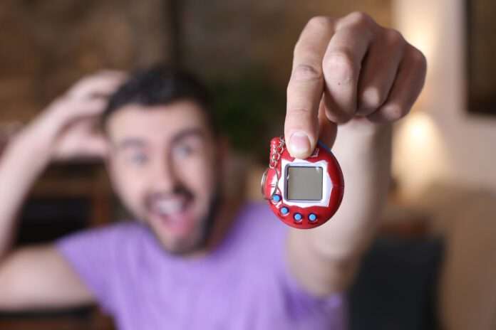 Millennial guy excited with his tamagochi